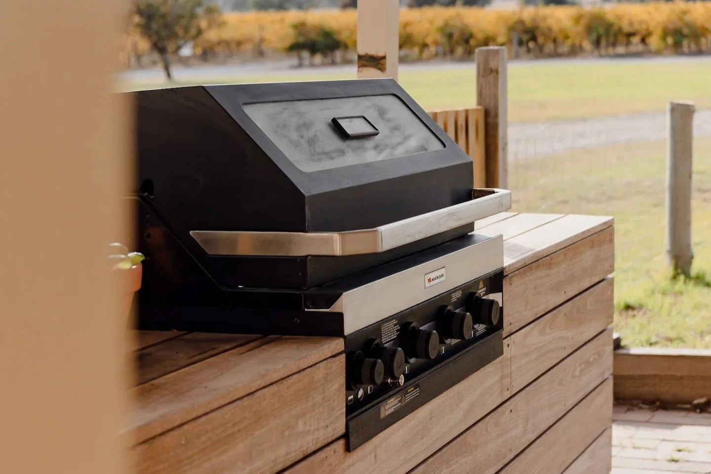 Hugo House, modern outdoor grill on a wooden deck with a scenic background