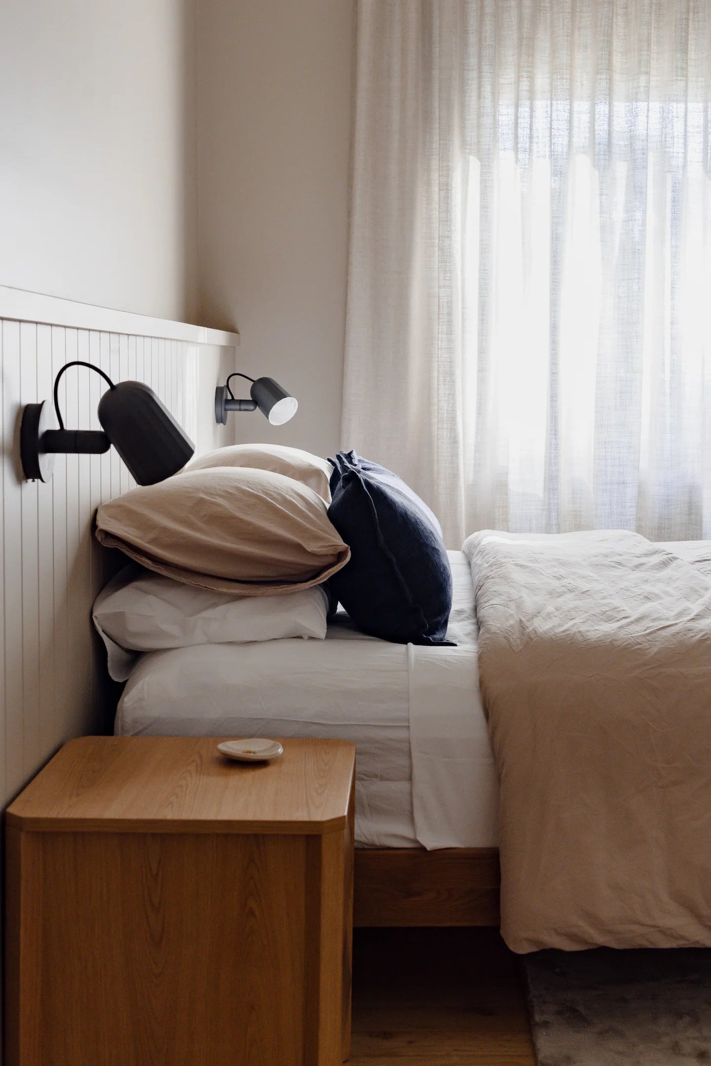 Hugo House, bedroom with a bed, nightstand, and wall lights.